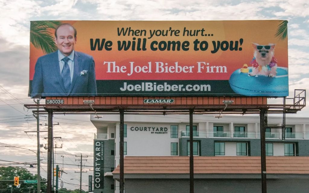 A billboard advertisement of The Joel Bieber Firm with Joel and his dog Bunkie.