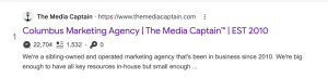 A Google search result snippet for The Media Captain marketing agency, showing integrated SEO data overlay metrics directly below the purple title link.