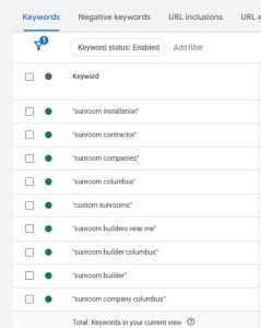 A Google Ads keyword management table showing a list of enabled phrase match keywords centered on sunroom construction terms like "sunroom installation" and "sunroom contractor".